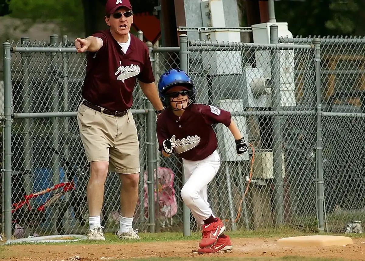 Batter at the plate with runners on base mid-swing, crowd blurred behind