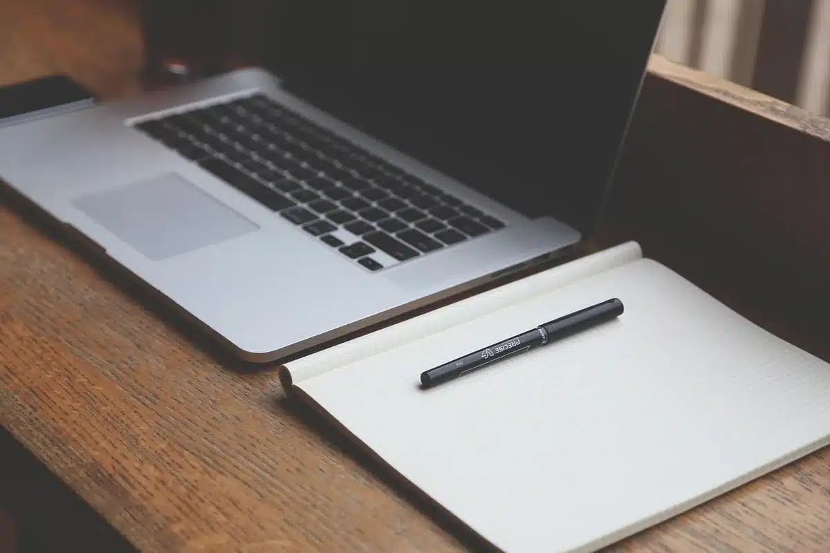 Anonymous meeting at a university table with laptop and documents in a bright corridor view