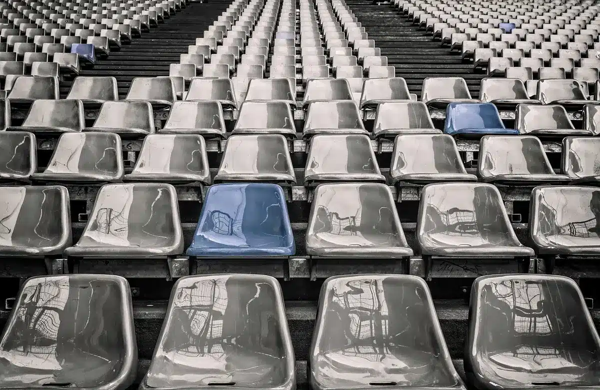 Empty stadium concourse with a discarded football helmet and program on concrete steps