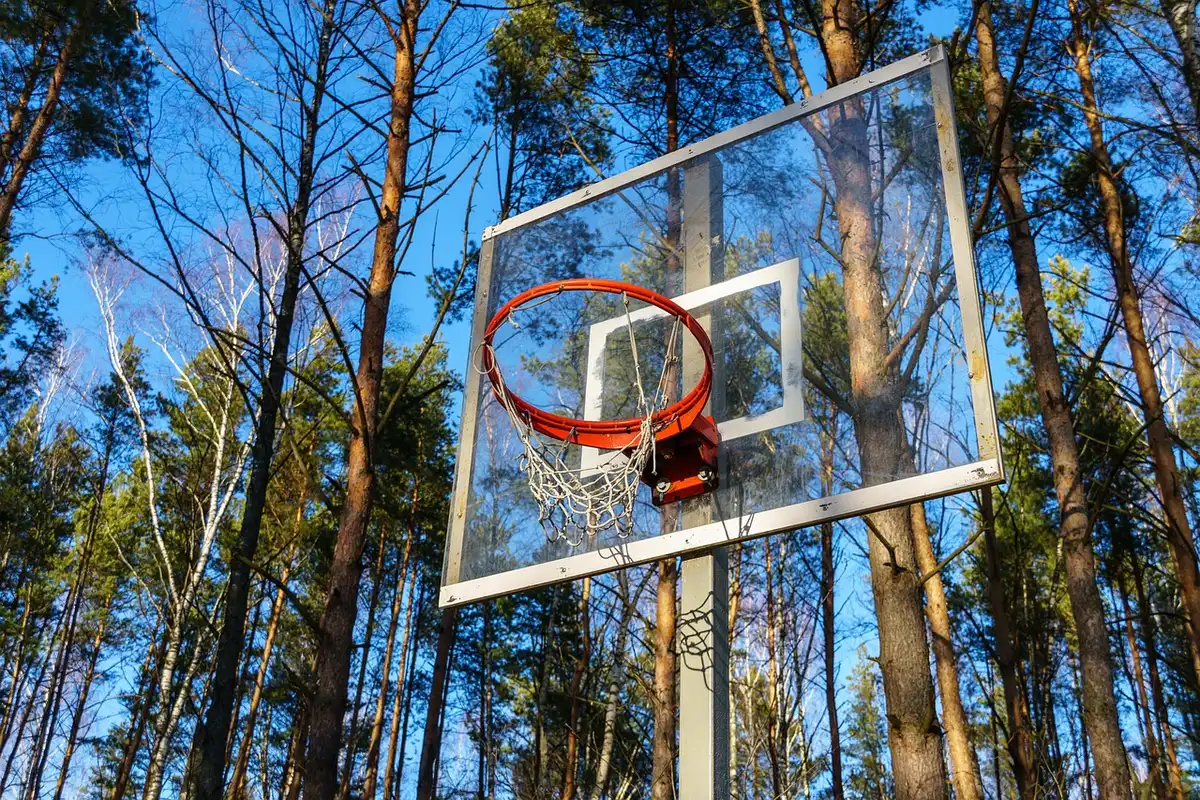 Basketball practice gym with hoop, sneakers and clipboard on bench