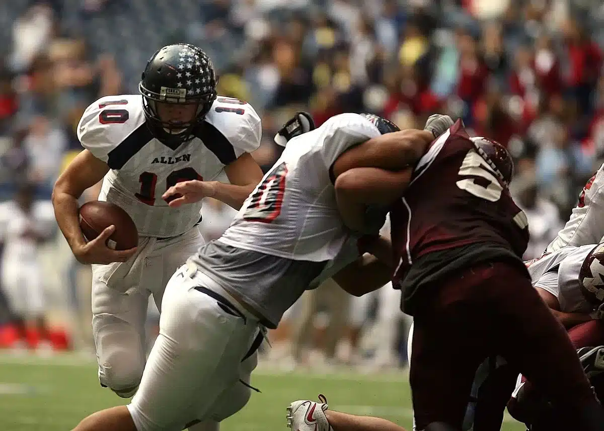 Quarterback scrambling with the ball during a college game, illustrating LaCrue's dual-threat play