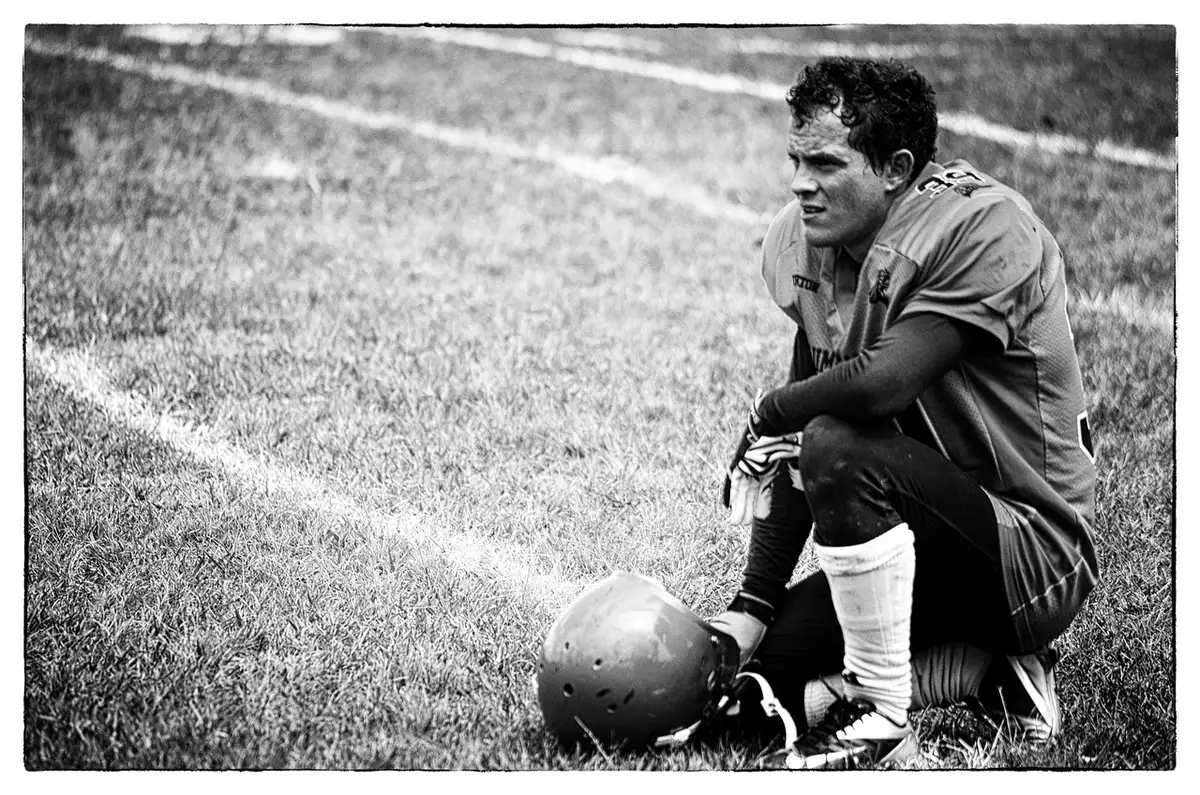 Quarterback helmet and practice gear on the sideline before a college game