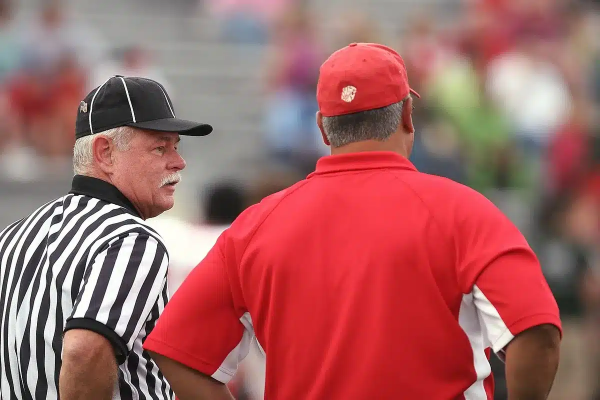 Coaching staff conferring on the sideline during practice