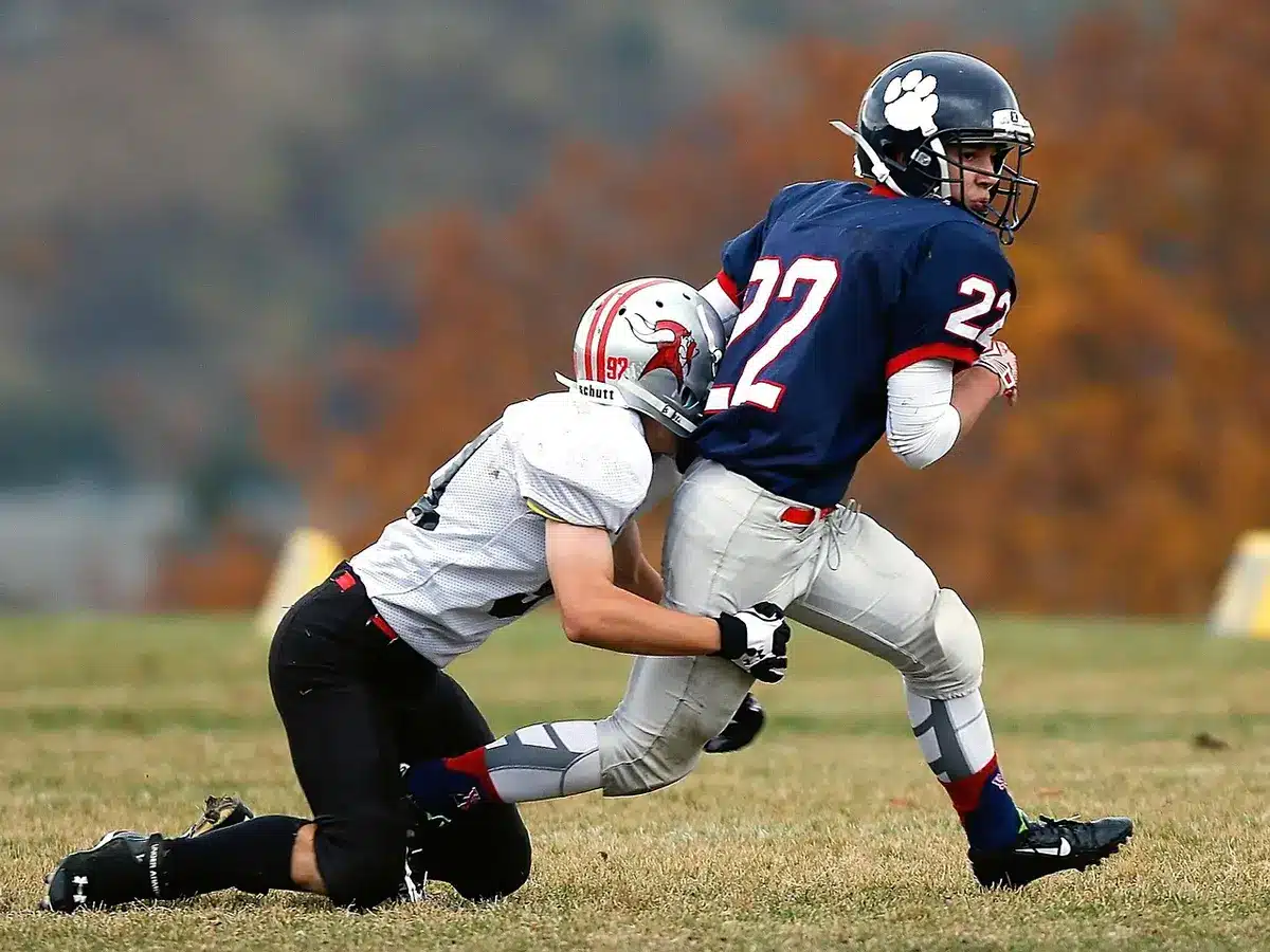 Notre Dame offensive tackle in practice stance with coach observing